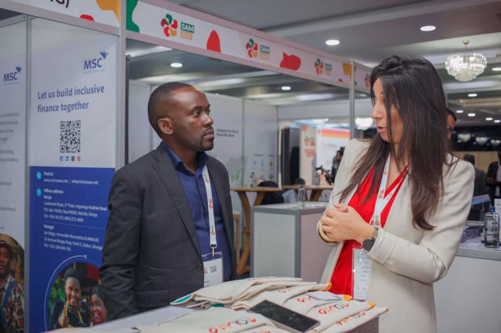 RDF representative discussing strategies for RDF Uganda Financial Inclusion with a partner at the conference booth.